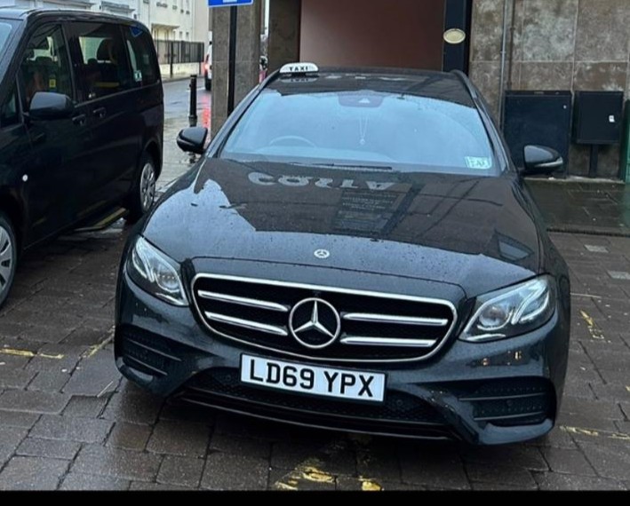 Local Taxi 4 seater black Mercedes saloon with a taxi roof sign