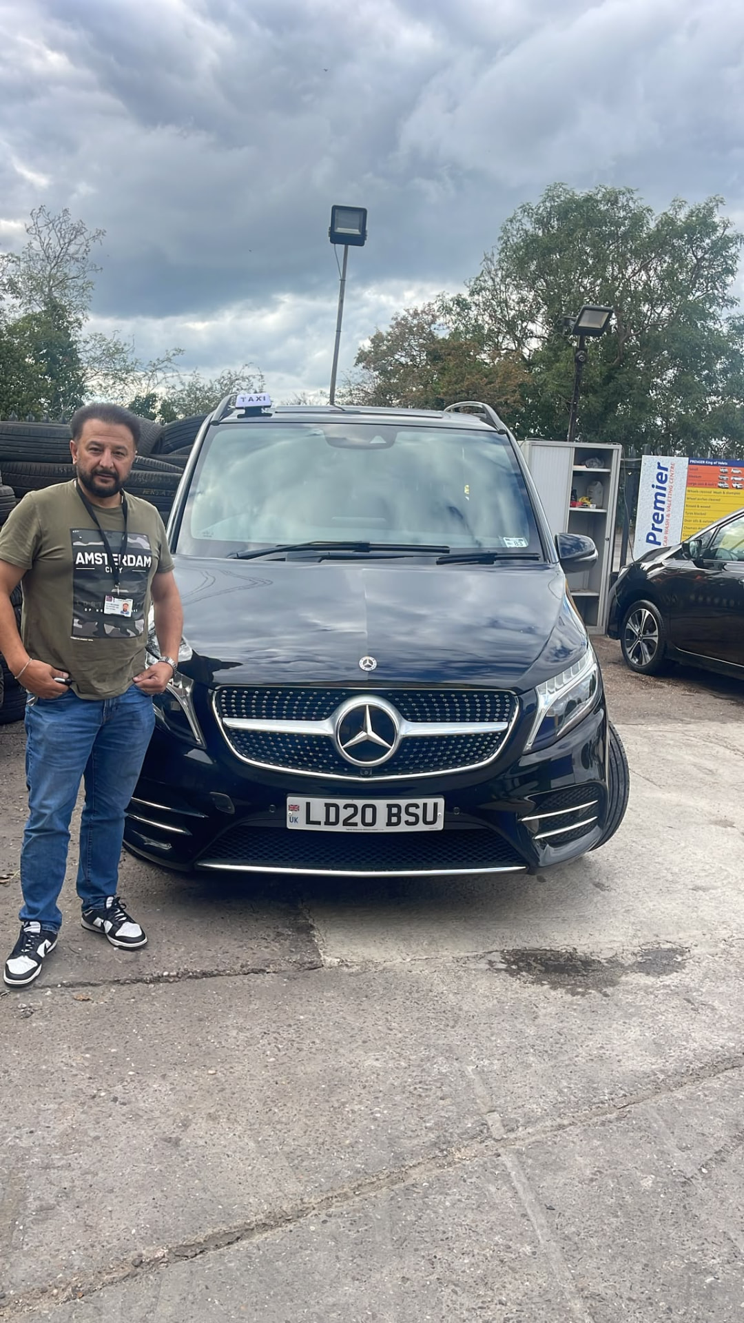 Local Taxi driver standing beside the 6 seater black Mercedes V-Class